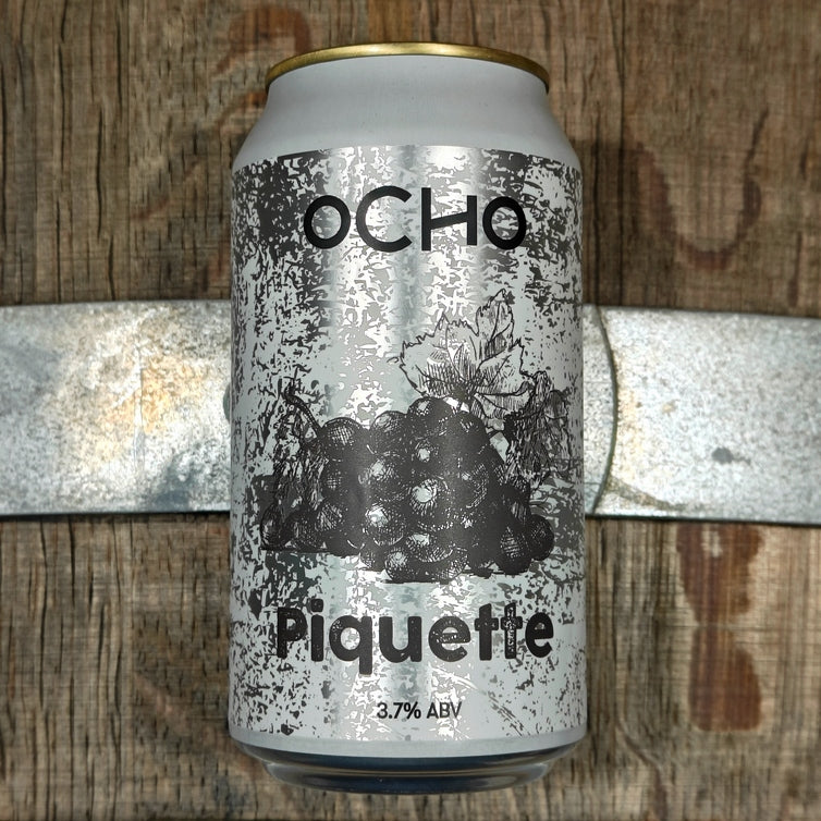 This is a photo of a can of a sour beer called Piquette on a wine barrel.